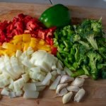 Chopped bell peppers, onions and garlic on board