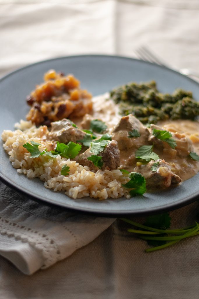 Beef Coconut Milk Curry on plate with chutney and saag