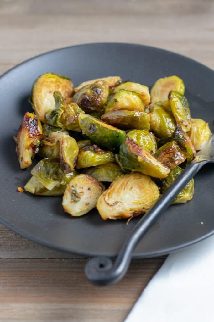 Baked brussels sprouts on a black plate