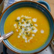 Butternut squash soup in blue bowl with garnishes