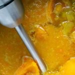 Immersion blender in pot of butternut squash soup