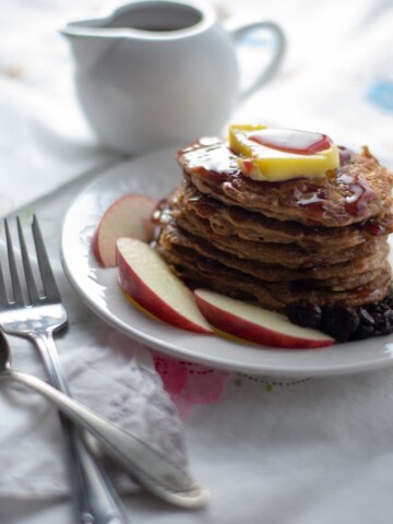 Flourless Oatmeal Pancakes with ghee and syrup on white plate