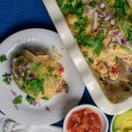 enchilada casserole on white plate and white baking dish with salsa in small dish