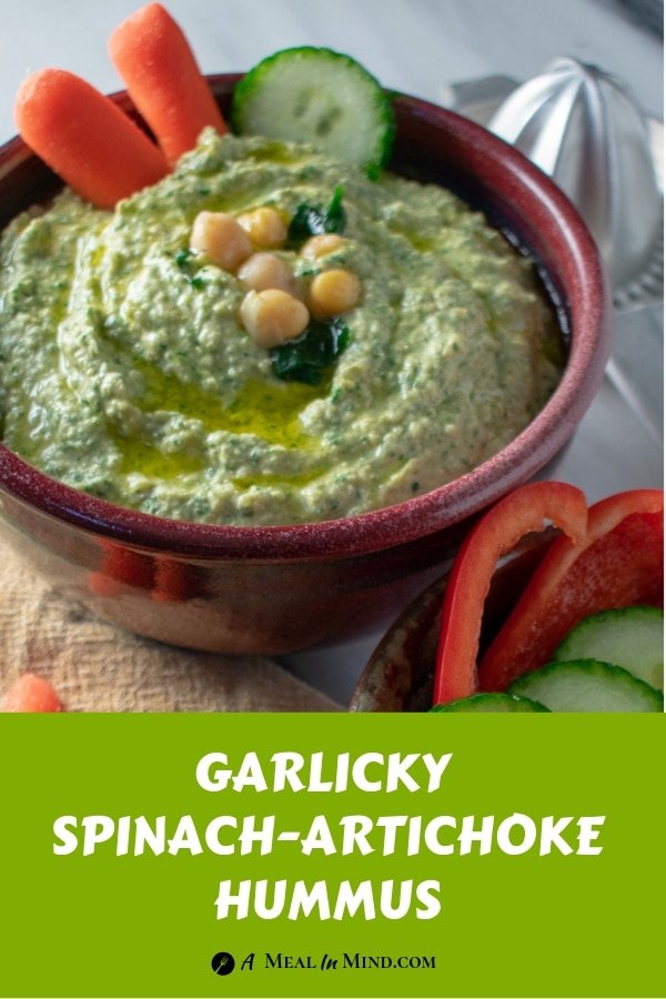 Garlicky spinach artichoke hummus in red bowl overhead view