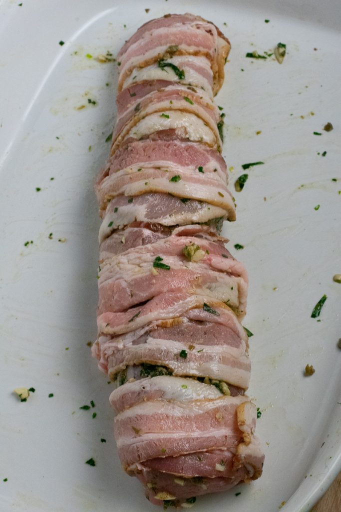 Pork tenderloin wrapped in bacon in baking dish