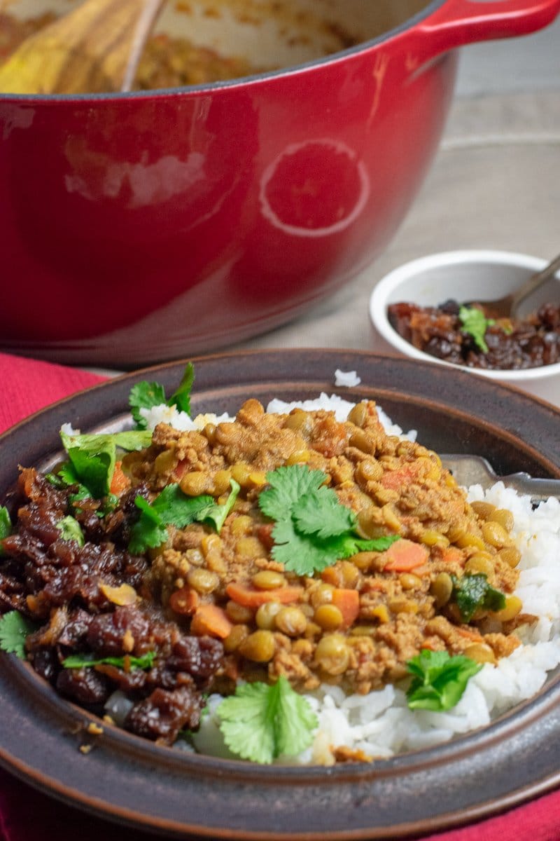 Spiced Lentils with Beef and chutney in brown bowl from side