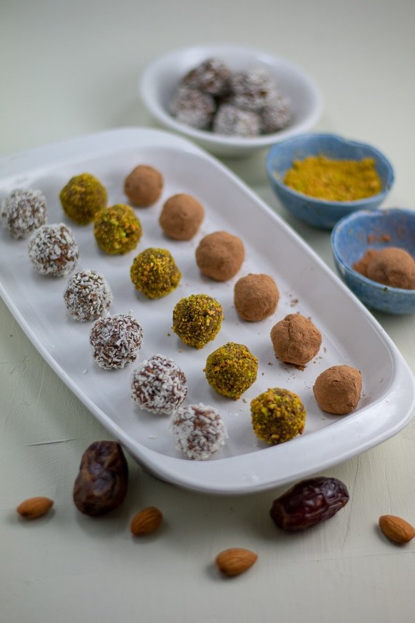 raw date-apricot almond butter bites in rows on white platter