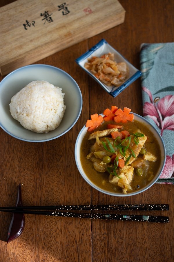 Japanese chicken curry and rice ball in small bowls with chopsticks