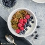moringa fruit-nut-ola in white bowl with berries and kefir