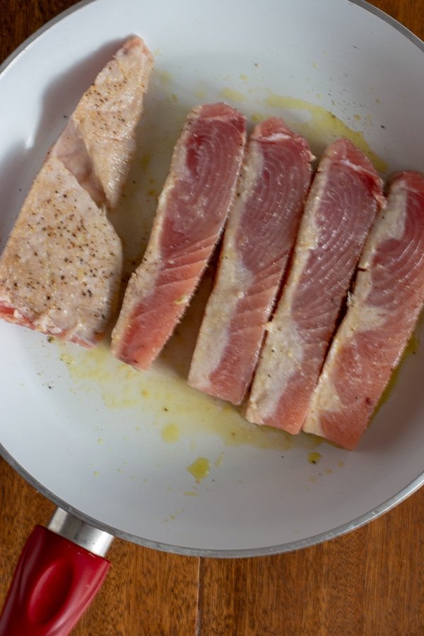 partly seared opah slices on white plate