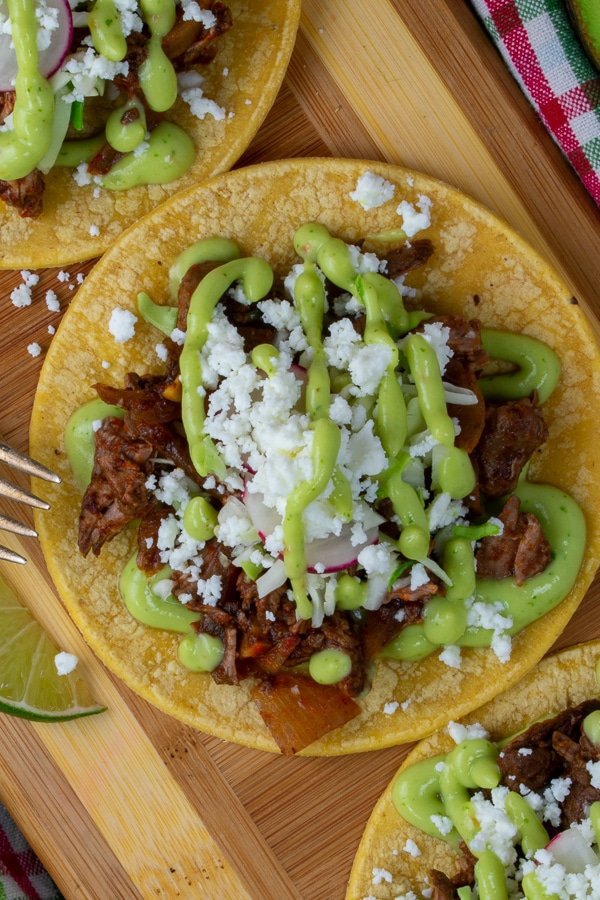 beef barbacoa taco slider with avocado lime dressing overhead view