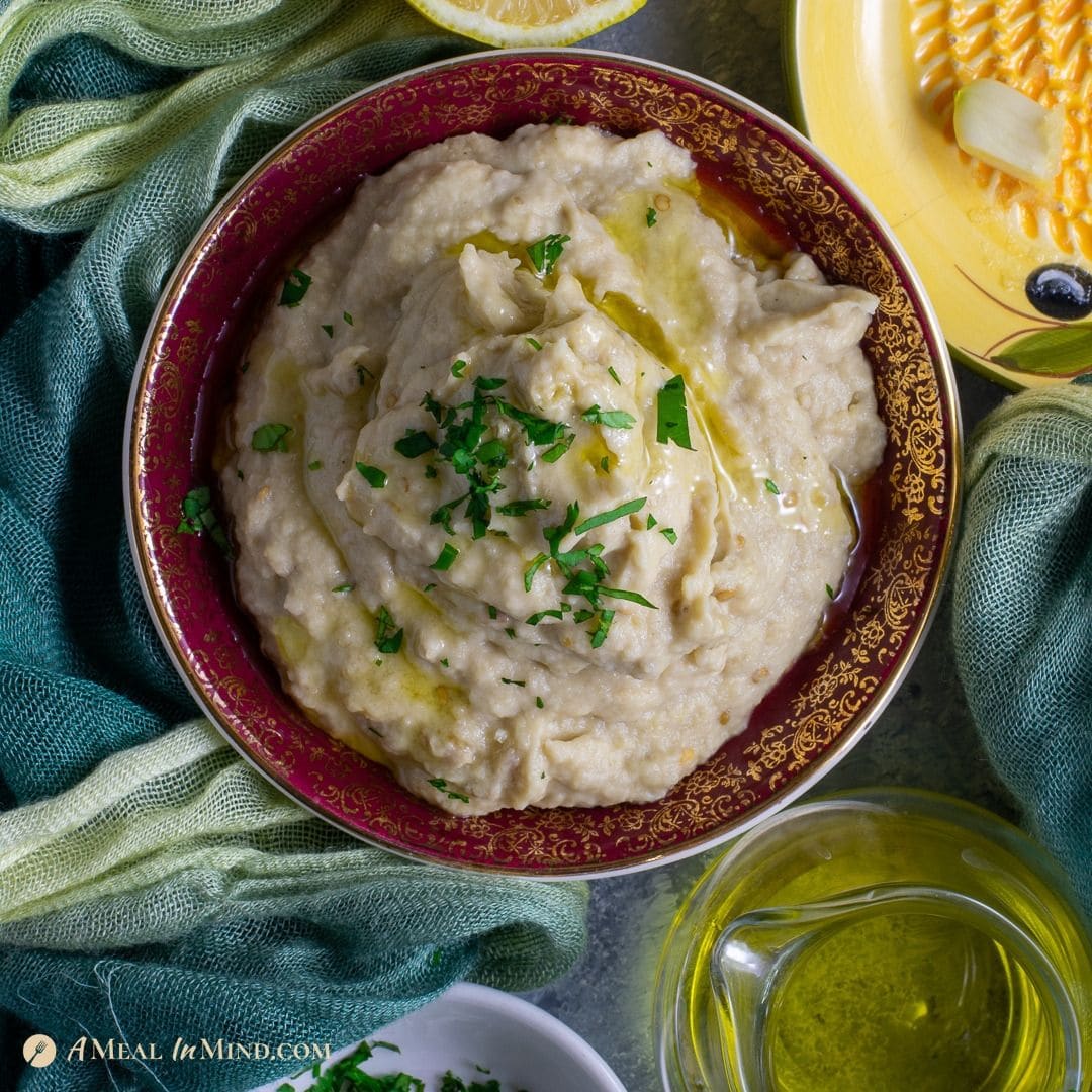 delicious baba ghanoush dip in red-rimmed bowl drizzled with olive oil