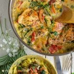 tuscan chicken with spinach, tomatoes, and artichokes in steel pan