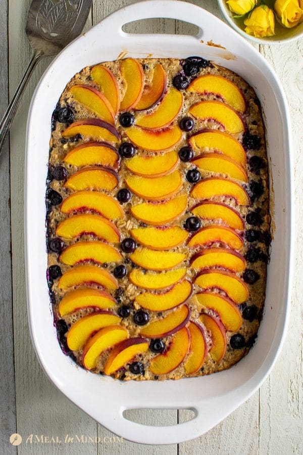 delicious peach oatmeal breakfast clafoutis in white baking pan