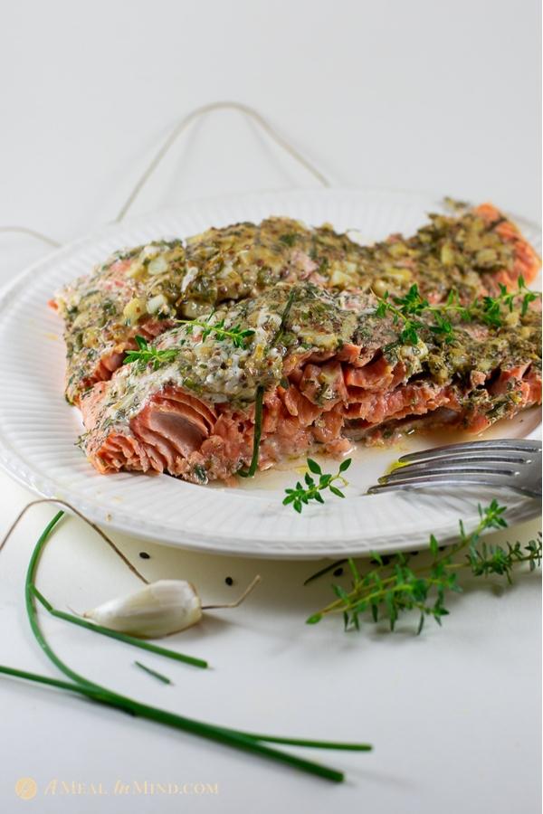 garlic dijon salmon baked in parchment, shown with some fish flaked away