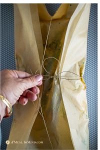 garlic herb salmon baked in parchment being tied