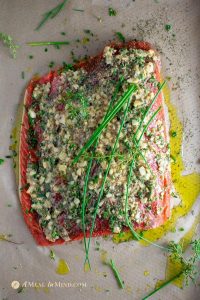 garlic herb salmon baked in parchment with sauce and herbs