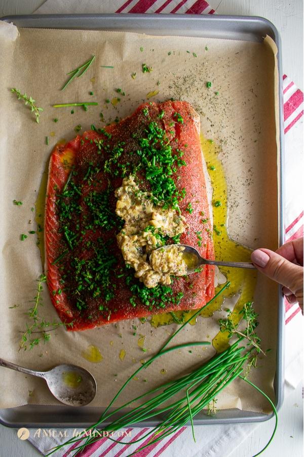 garlic herb salmon baked in parchment applying the garlic paste