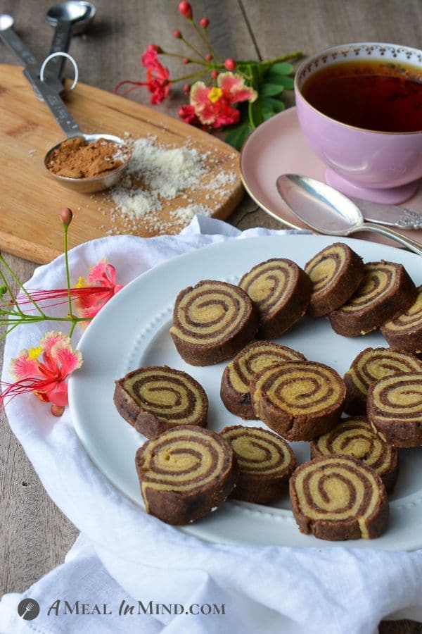 Almond Flour Carob Pinwheel Cookies with a cup of tea and flowers