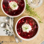 Beet-Cabbage Borscht Soup in white bowls on burlap