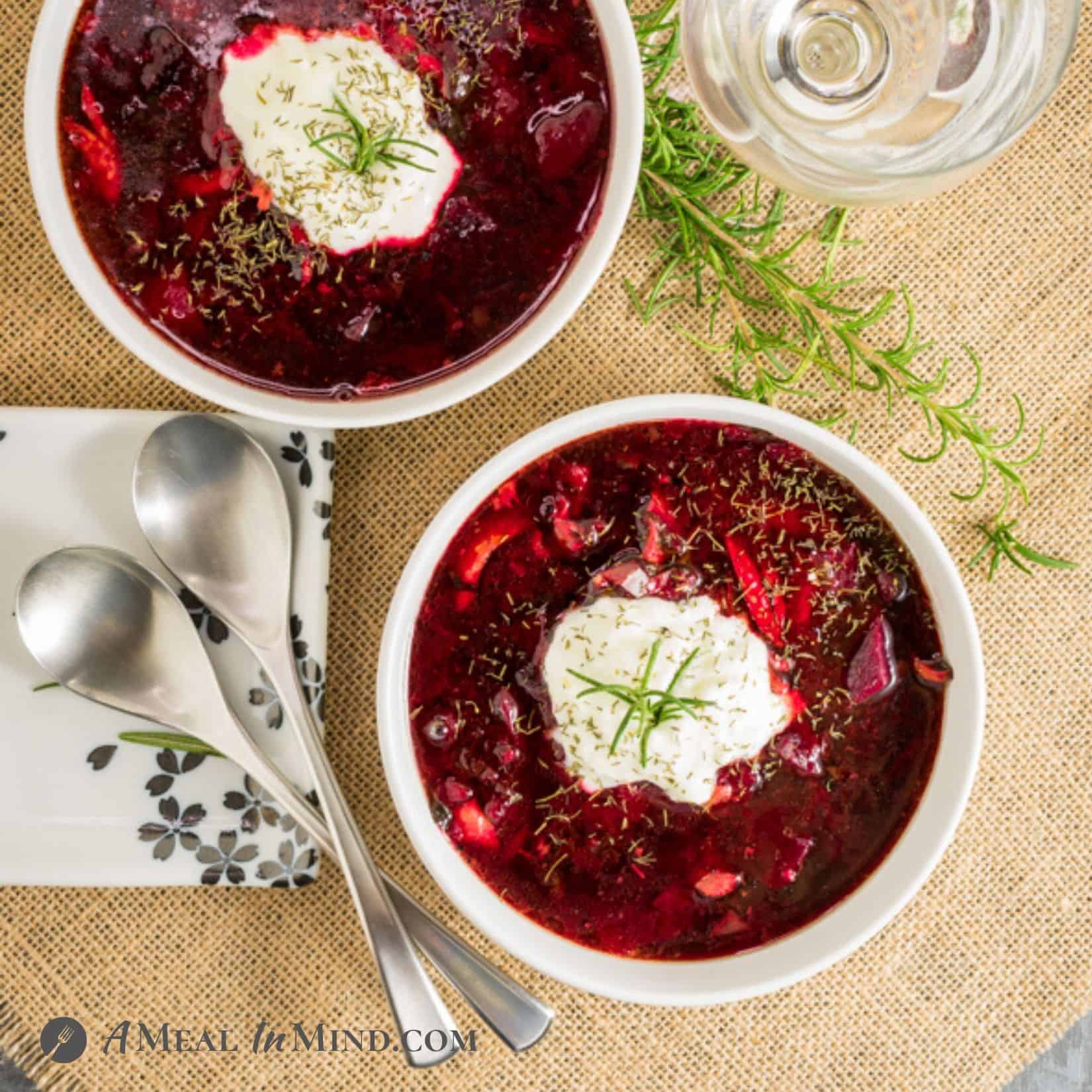 Beet-Cabbage Borscht Soup in white bowls with yogurt topping