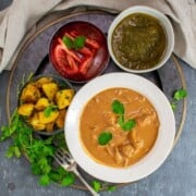 One-Pot Butter Chicken in white bowl with side dishes