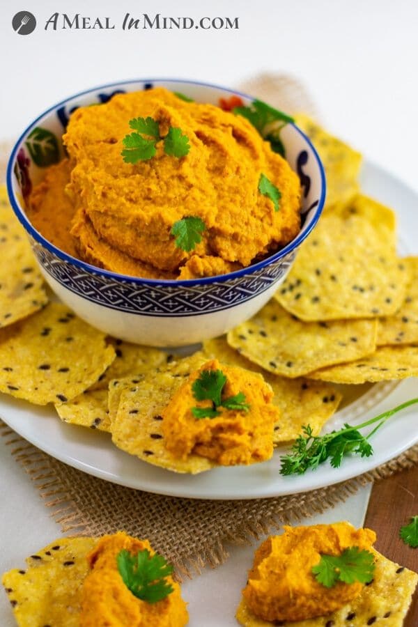 Moroccan Roasted-Carrot Hummus in patterned bowl side view with chips