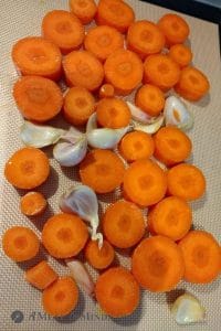 carrots and garlic for Moroccan Roasted-Carrot Hummus on baking sheet