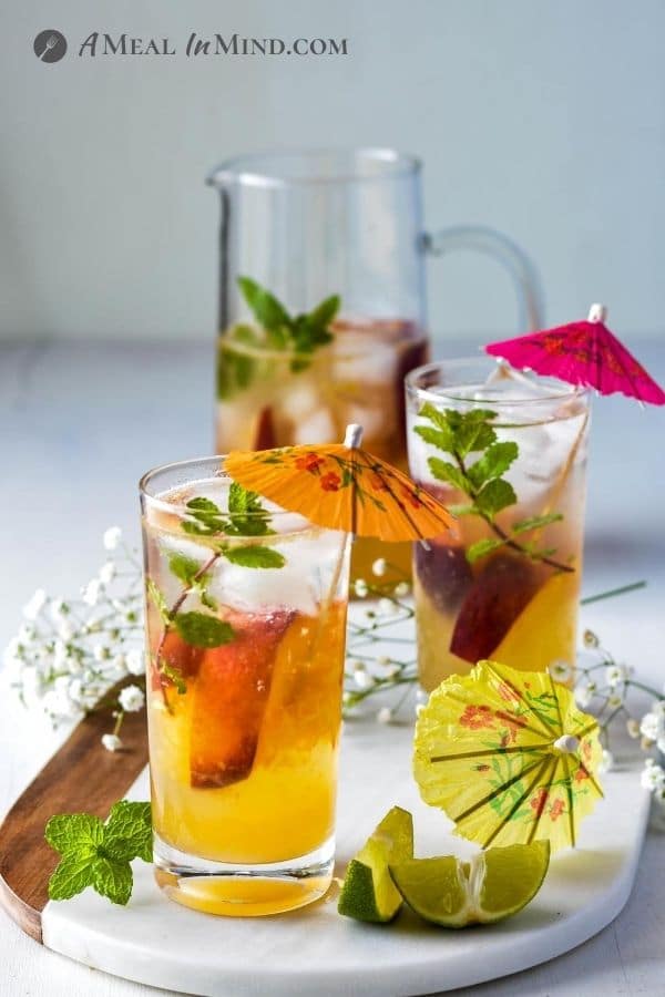 Peach-Ginger Limeade Mocktail in glasses and pitcher with umbrellas