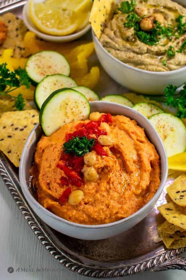 close-up of red bell pepper hummus in ivory bowl
