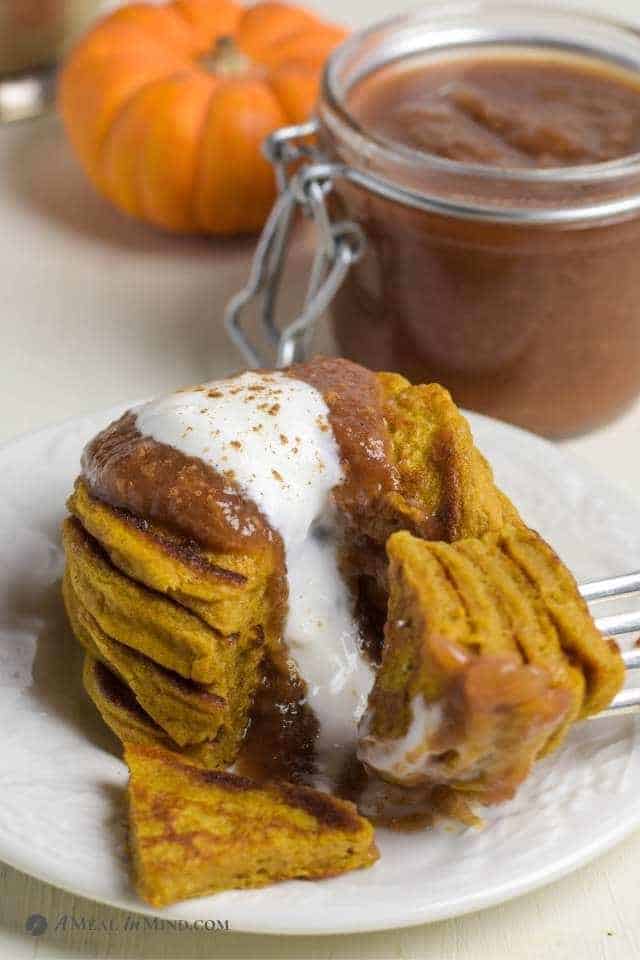 Pumpkin Protein Pancakes in a stack with yogurt and apple butter