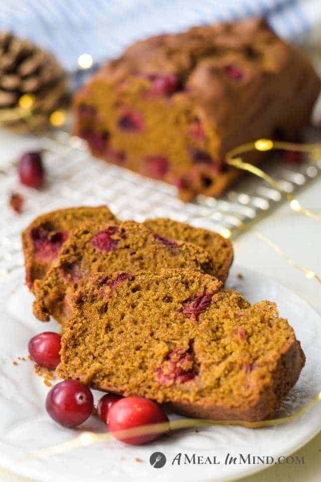 cranberry pumpkin bread sliced on white plate with lights