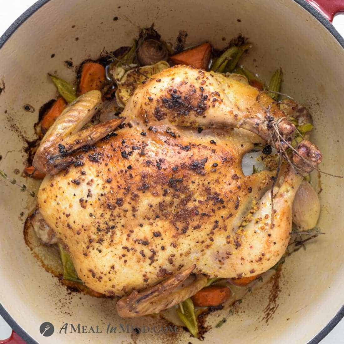 chicken roasted in dutch oven on a bed of vegetables