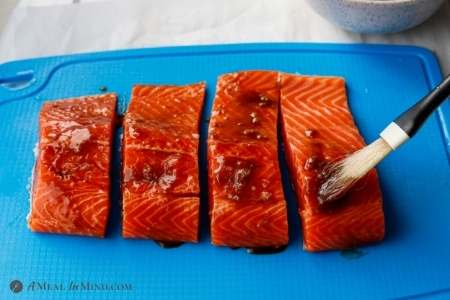 brushing hoisin sauce mixture onto salmon fillets