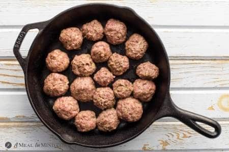 Paleo Pesto Meatballs in skillet after rolling