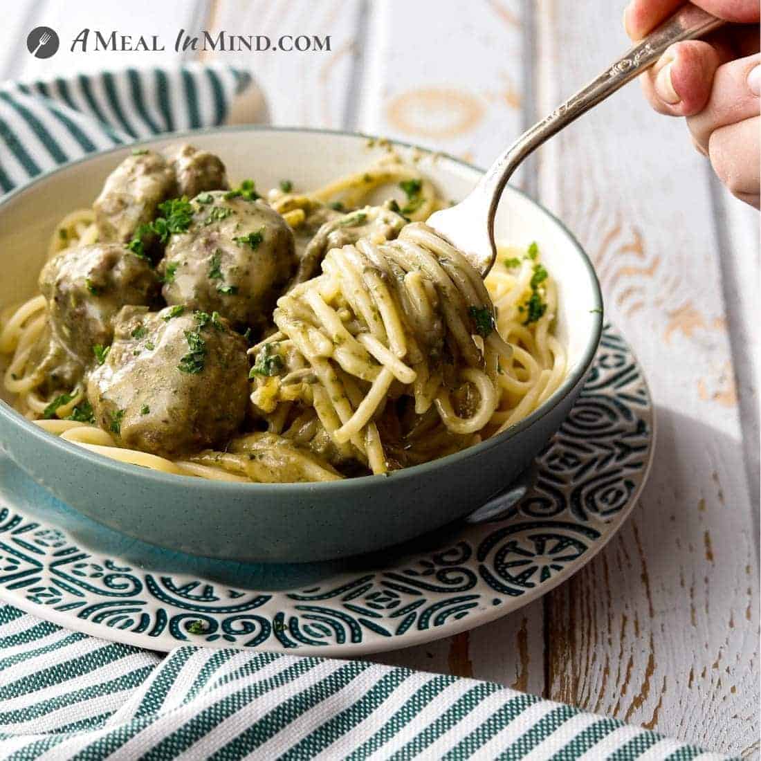 Paleo Pesto Meatballs and Alfredo Sauce in bowl on gf pasta