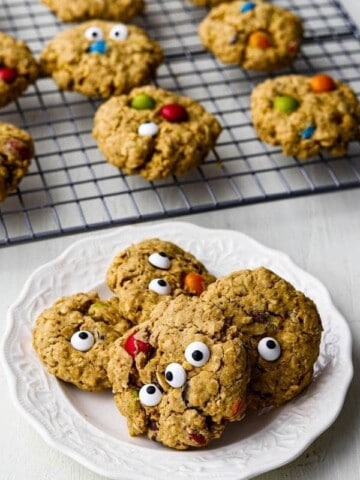 monster cookies on white plate with rack in background