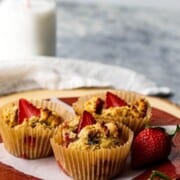 paleo strawberry muffins on a red plate with milk in background